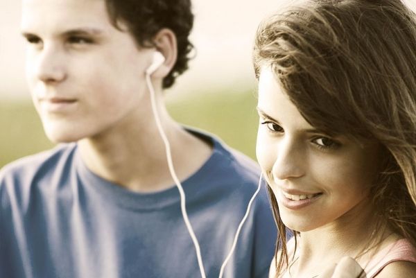 Teens partage écouteurs, écouter de la musique en plein air. Heure d'été.