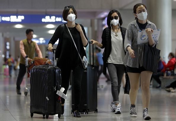 Voyageurs dans un asiatiques portent des masques de l'aéroport pour aider à prévenir la propagation du MERS.