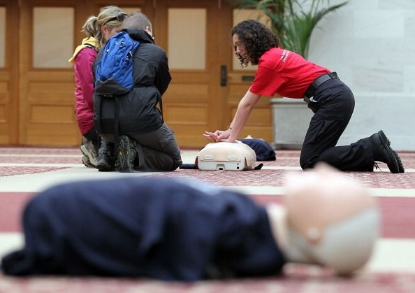 Un homme montre deux personnes comment effectuer la RCR sur un mannequin. Un homme montre deux personnes comment effectuer la RCR sur un mannequin.