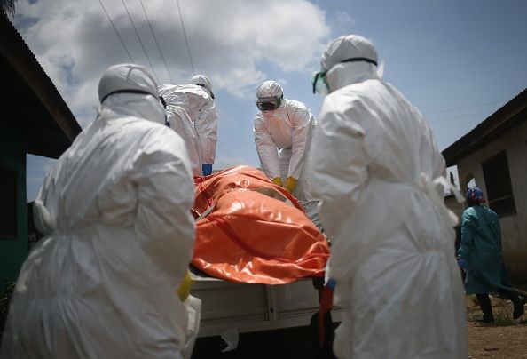 Les travailleurs qui manipulent le corps d'une victime d'Ebola au Libéria. Restrictions de la santé se sont affrontés avec les pratiques funéraires dans la Guinée voisine. Les travailleurs qui manipulent le corps d'une victime d'Ebola au Libéria. Restrictions de la santé se sont affrontés avec les pratiques funéraires dans la Guinée voisine.