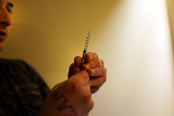 Un utilisateur de drogue opioïde prépare une aiguille pour injection.