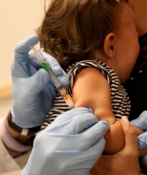 Un enfant se fait vacciner. Les taux de vaccination sont élevés ensemble, mais des poches du pays havemany enfants non protégés