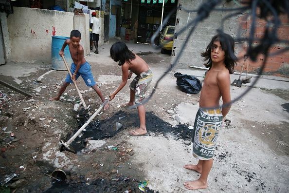 Chidren tenter de déboucher un égout à Rio de Janeiro. Ouvrir eaux usées comme cela pourrait propager la fièvre typhoïde. Chidren tenter de déboucher un égout à Rio de Janeiro. Ouvrir eaux usées comme cela pourrait propager la fièvre typhoïde.