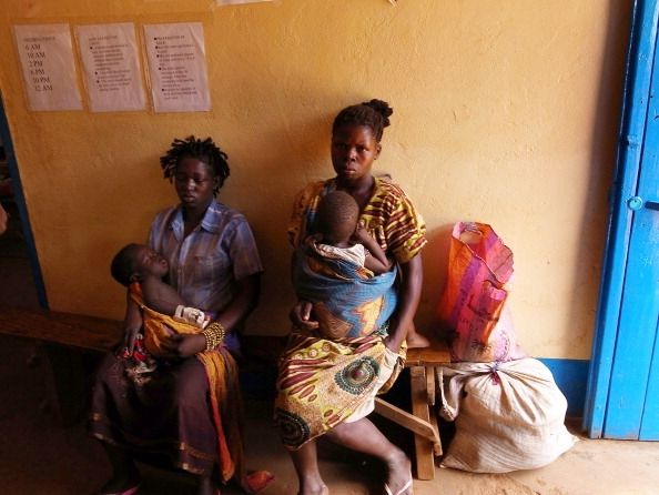 Une mère et ses enfants au Soudan attendent le traitement du paludisme.