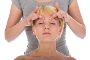 Jolie femme sur le traitement de massage de la tête isoalted sur fond blanc